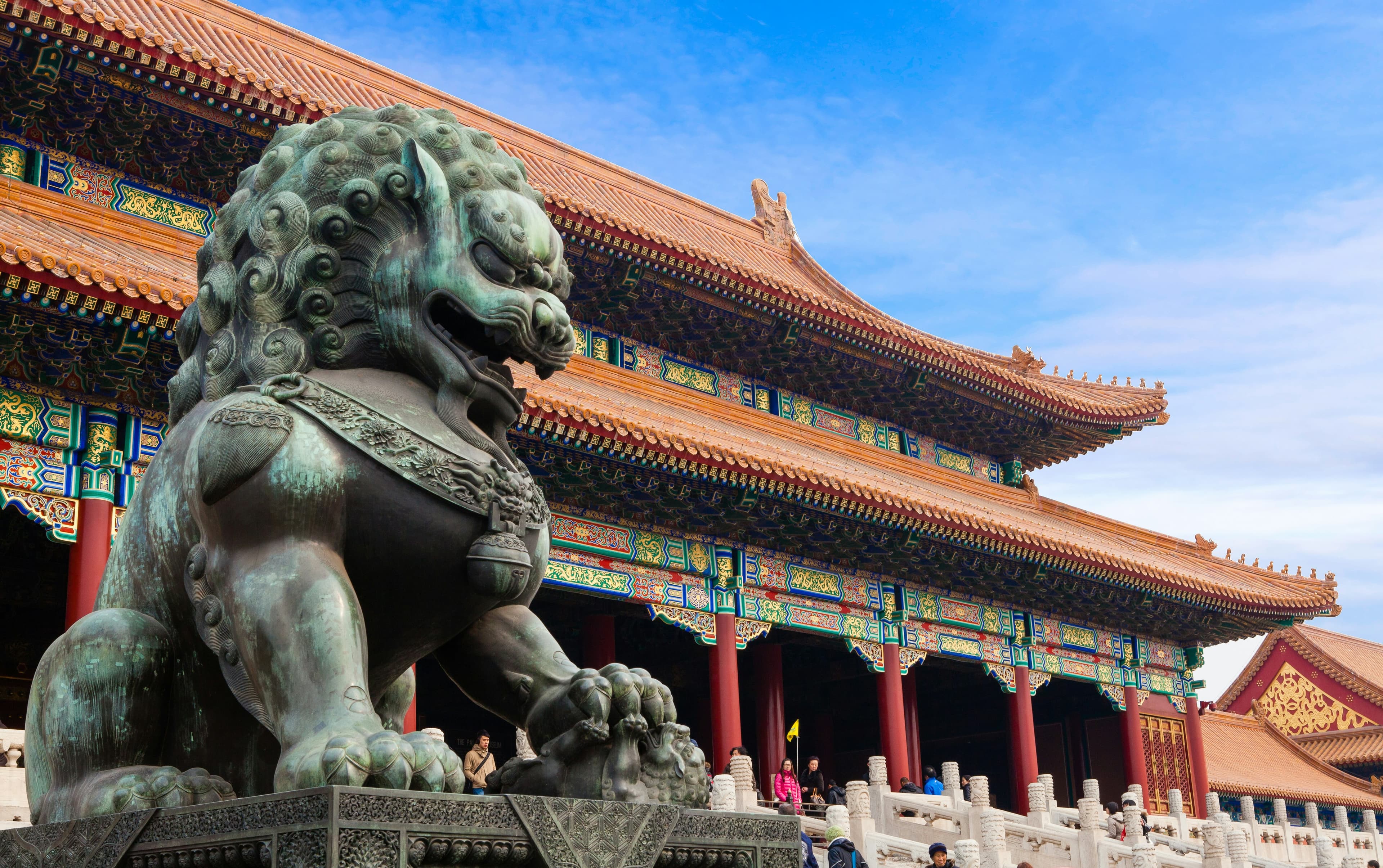 A bronze guardian lion beside the ornate halls of Beijing’s Forbidden City
