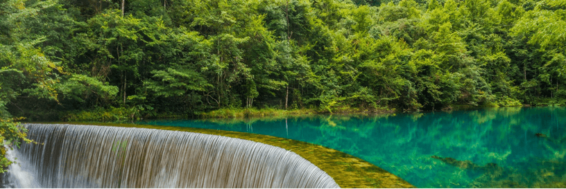 Clear water and a forest-lined cascade in Guizhou