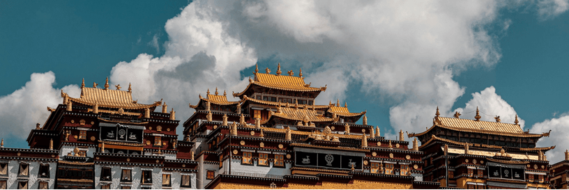 Traditional monastery architecture beneath clouds in Yunnan